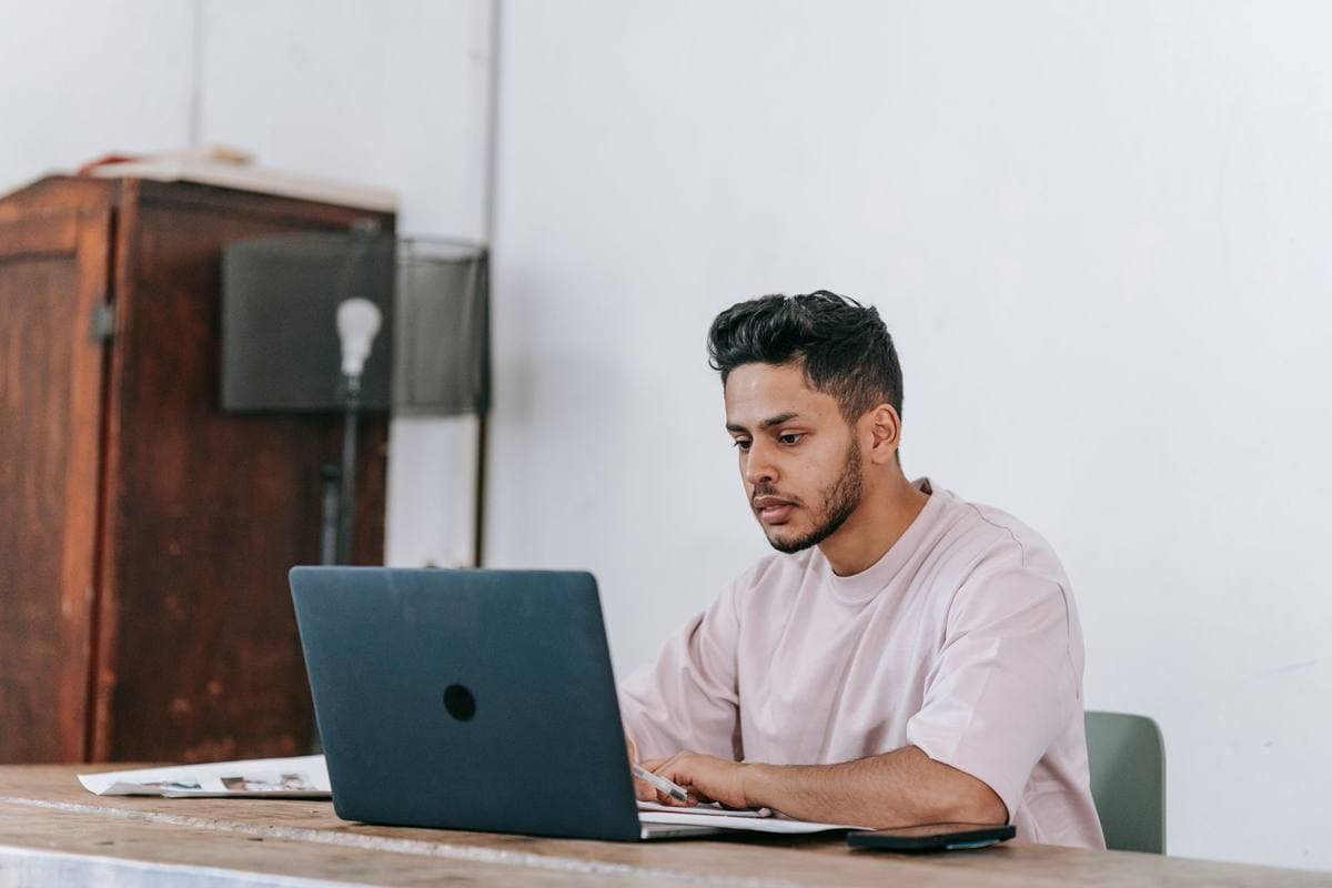 A man working on a laptop at a table at home